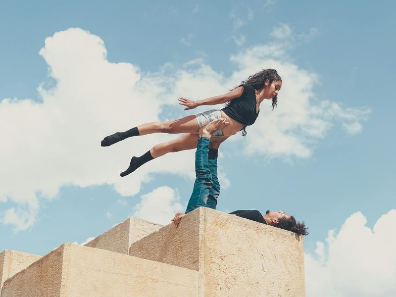 Man performing a controlled bodyweight exercise in a minimalist room.