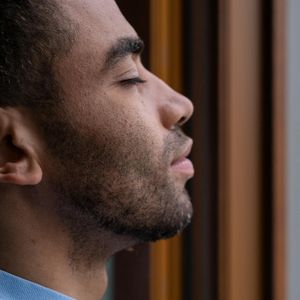 Side profile of a man breathing deeply with eyes closed.
